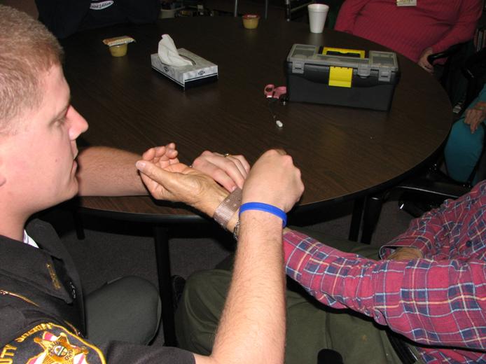 Image of Project Lifesaver device being placed on a wrist